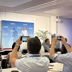 Dr. Wolfgang Huhn auf der Bühne während seines Vortrags auf der Automotive Lighting Conference 2026. Im Vordergrund werden Fotos aus dem Publikum gemacht.