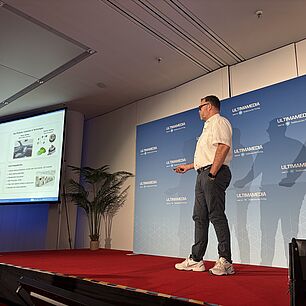 Dr. Michael Olbrich auf der Bühne während seines Vortrags bei der Automotive Lighting Conference 2026 in München