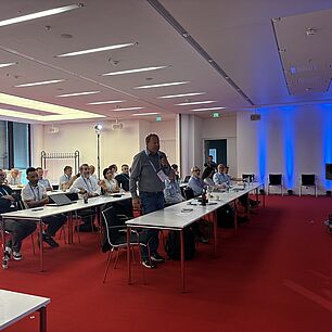 Robert Isele steht im Publikum und stellt eine Frage auf der Automotive Lighting Conference 2026